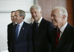 President George W. Bush (second from left), walks with, from left, former President George H.W. Bush, former President Bill Clinton, and former President Jimmy Carter during the dedication of the William J. Clinton Presidential Center and Park in Little Rock, Arkansas, November 18, 2004.