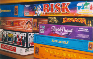 A shelf full of board games, including Risk, Monopoly and Trivial Pursuit.