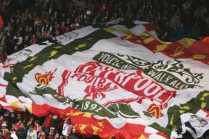 Fans on the Kop hold aloft the team badge