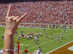 A student giving the Hook 'em Horns hand gesture at a Longhorn football game.