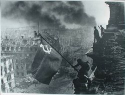 Marking the Soviet Union's victory, a soldier raises the Soviet flag over the German Reichstag in the Nazi capital of Berlin.