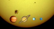 The solar system's four gas giants against the Sun's limb, to scale