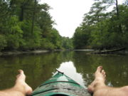 Feet propped up on a kayak. Kayaking is considered a leisure sport.